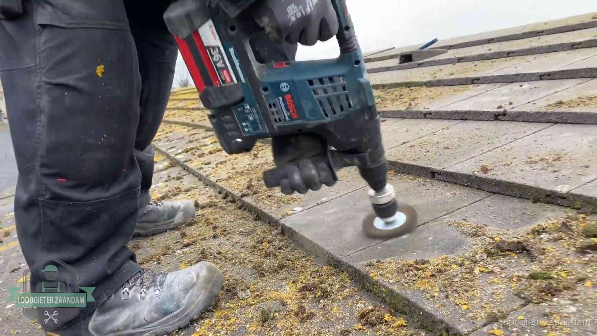 Dakonderhoud en preventie in Zaandam Betonnen dakpannen worden machinaal gereinigd tijdens dakonderhoud in Zaandam