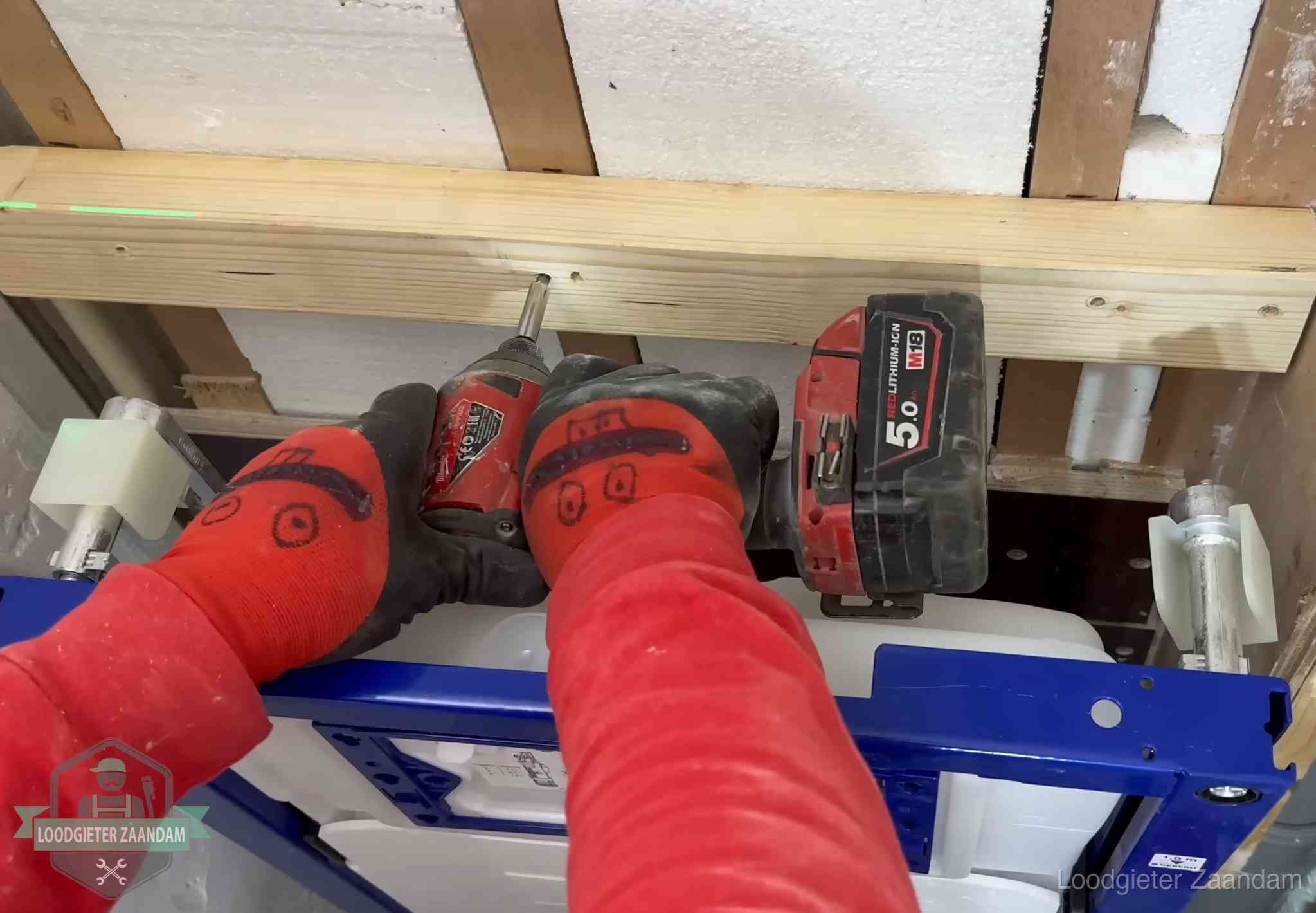 Monteur bevestigt een inbouwreservoir voor een hangend toilet in Zaandam