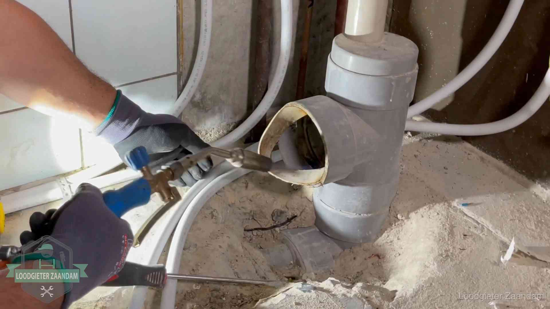 Vakmanschap van onze loodgieters in Zaandam Loodgieter werkt met brander en messing kraanwerk aan leidingen in Zaandam