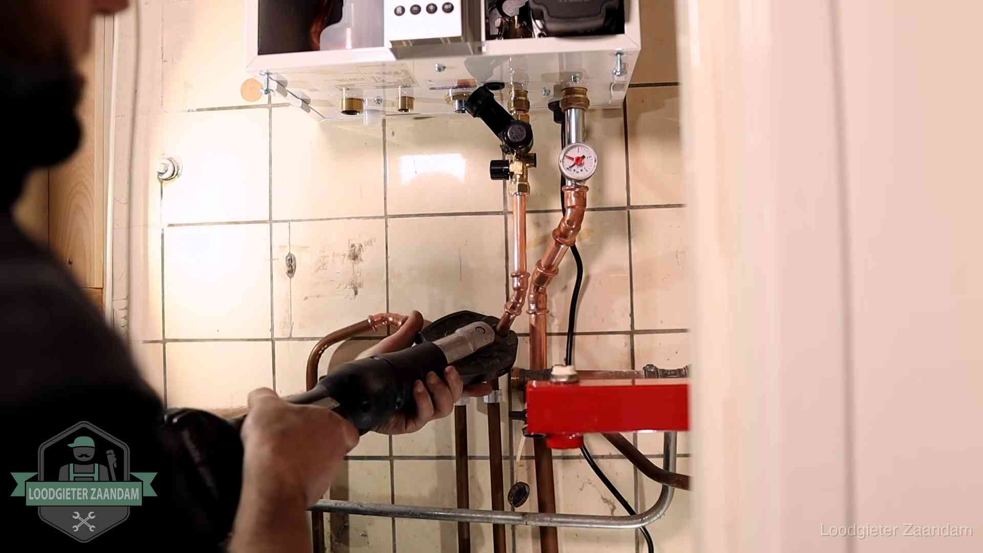Cv-ketel onderhoud in Zaandam Monteur werkt aan de leidingen onder een cv-ketel in Zaandam