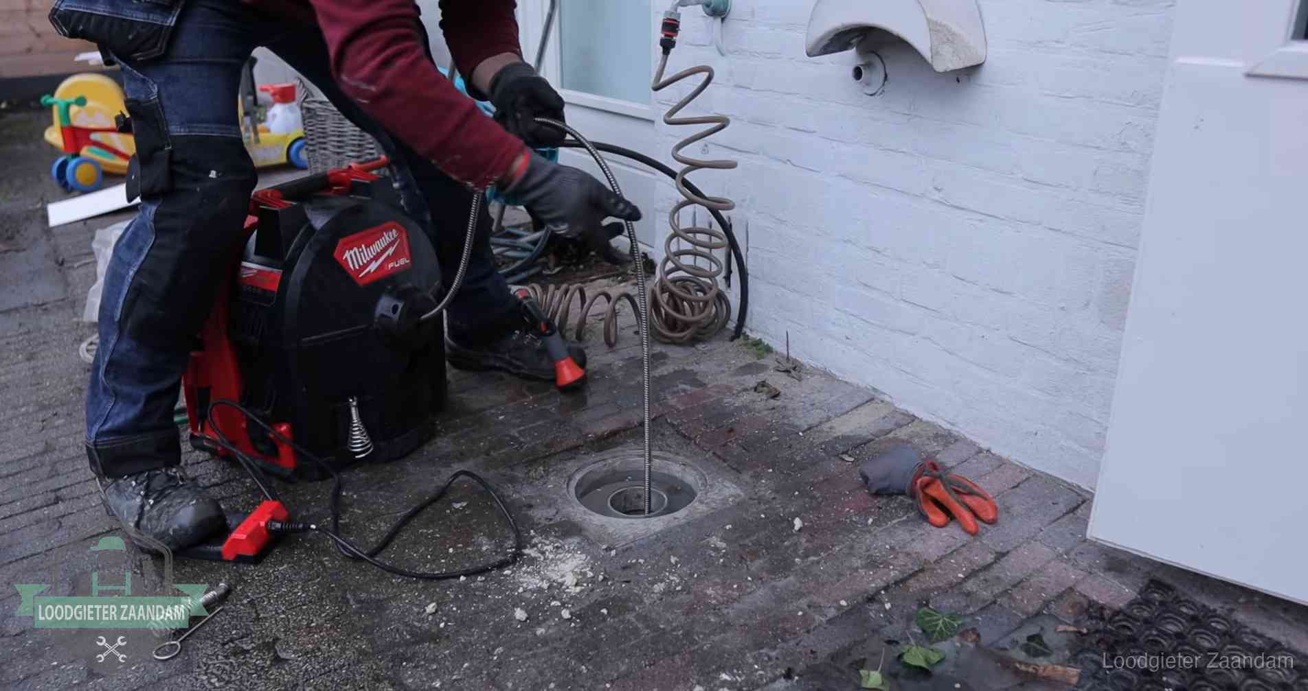 Erfgrens en gemeenteriool in Zaandam Ontstoppingsputje in de bestrating naast de gevel van een woning in Zaandam