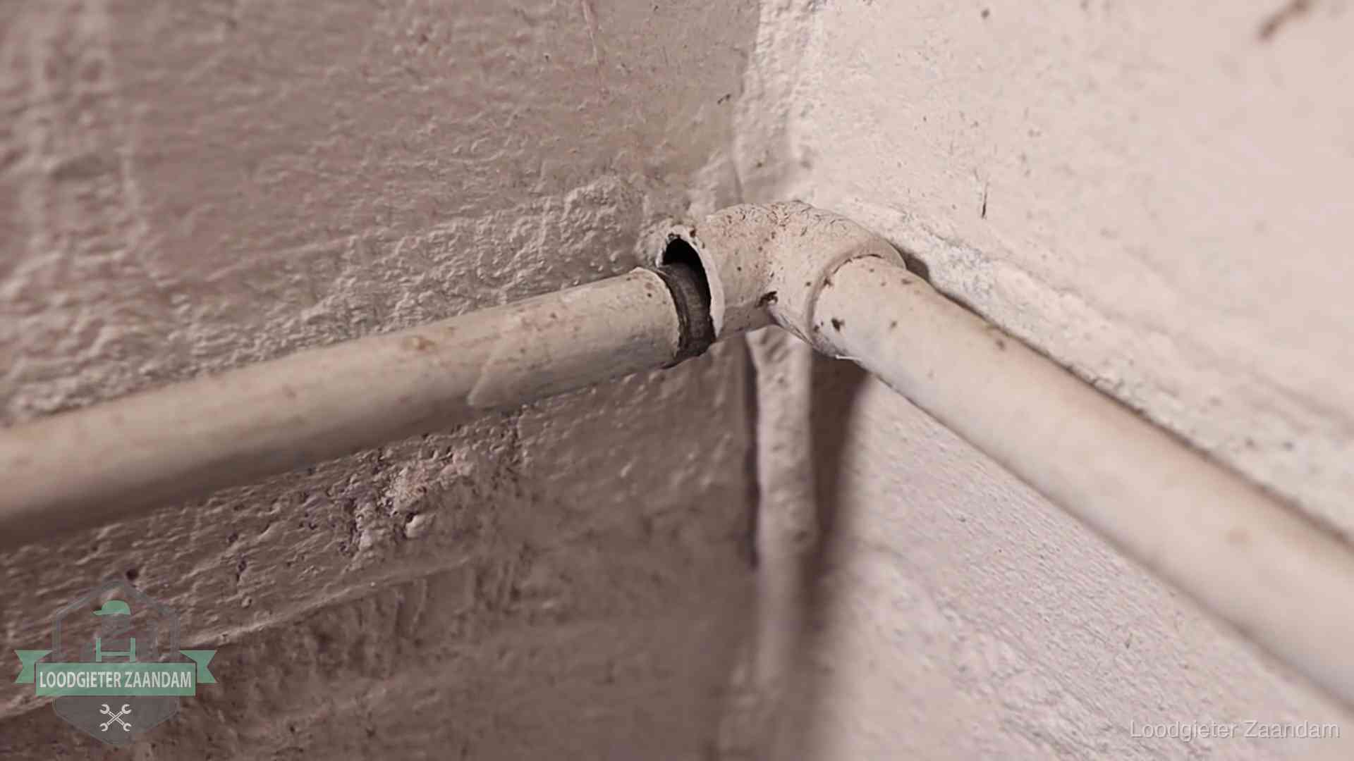 Oude waterleidingen en verborgen lekkage in Zaandam Oude geverfde waterleiding met een losliggende fitting in een woning in Zaandam