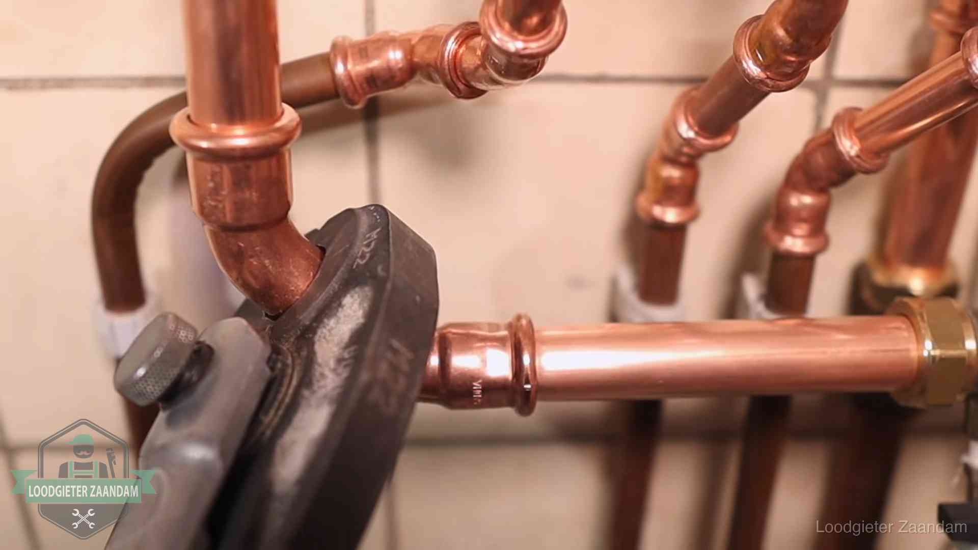 Werkwijze van ons loodgietersbedrijf in Zaandam Persmachine perst een koperen fitting op nieuw leidingwerk in Zaandam