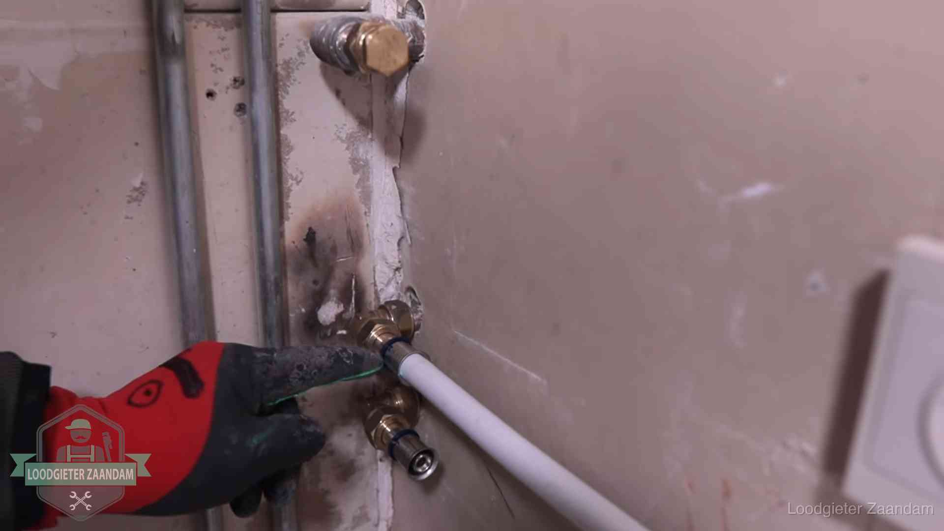 Garantie op loodgieterswerk in Zaandam Loodgieter wijst de persfitting op nieuwe muuraansluitingen aan in een woning in Zaandam