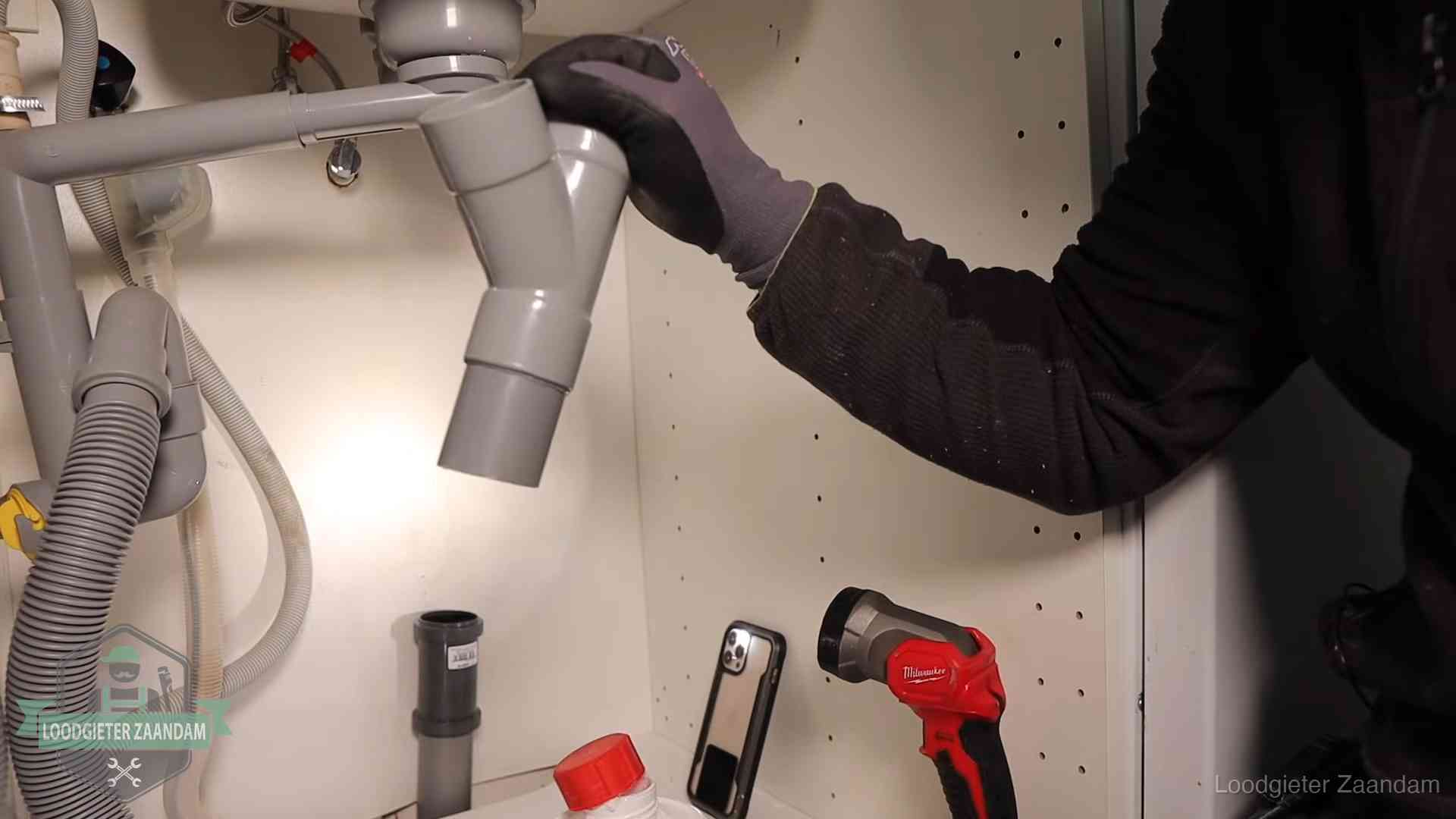 Rioollucht in huis verhelpen in Zaandam Loodgieter demonteert het sifon- en afvoerwerk onder een gootsteen in Zaandam bij stankklachten