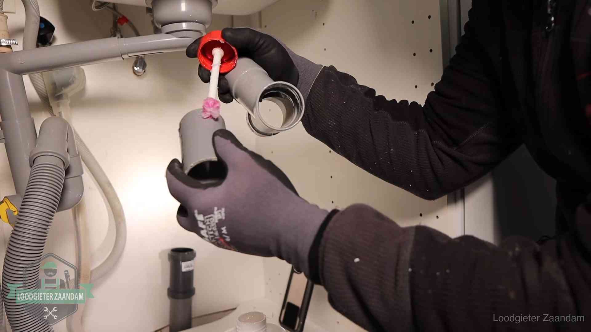 Oorzaak van een verstopte afvoer in Zaandam Loodgieter demonteert en reinigt de sifon onder een keukenkast in Zaandam