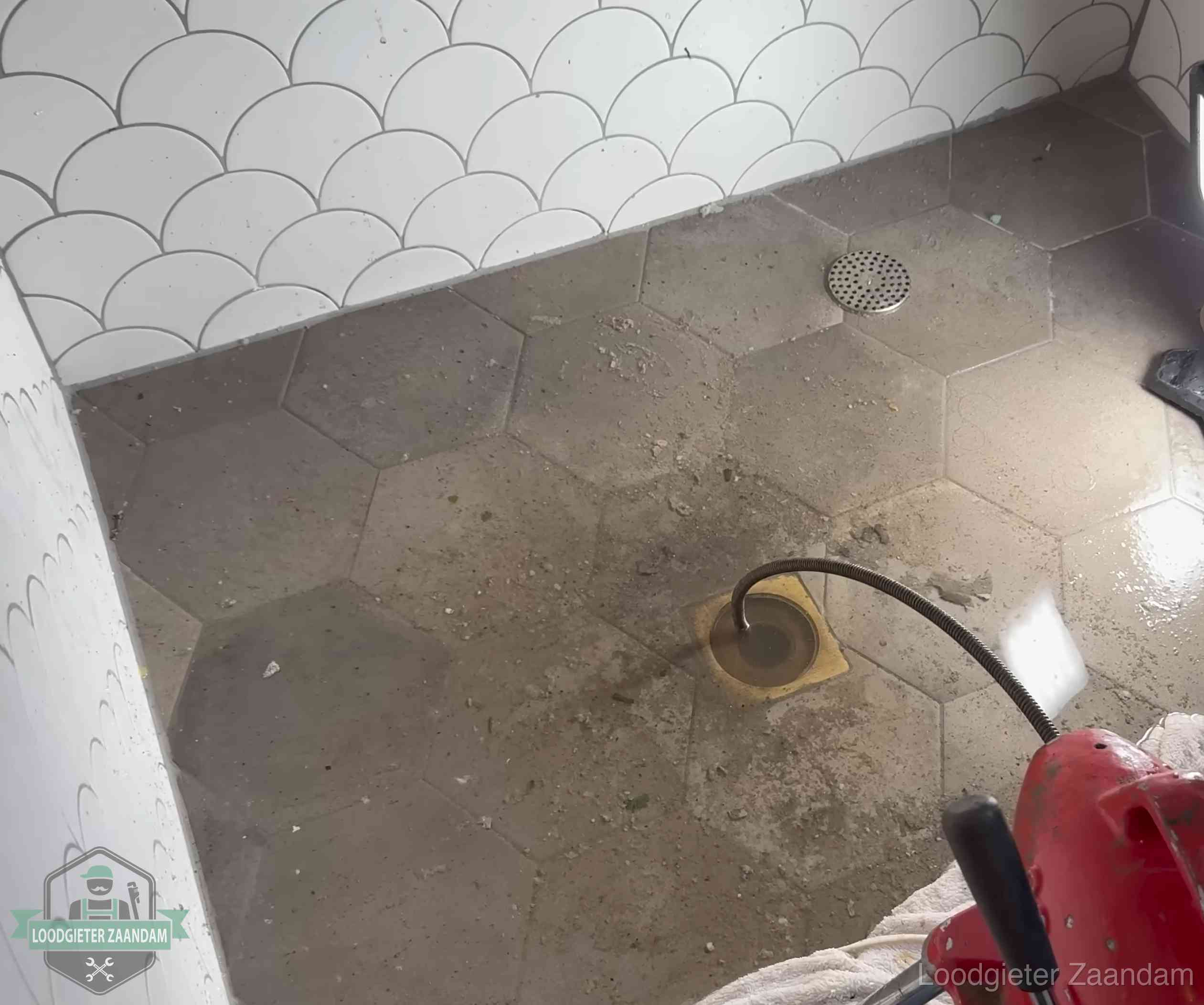 Vloerput met waterslot in een badkamer in Zaandam, een bron van stank als het waterslot droogstaat