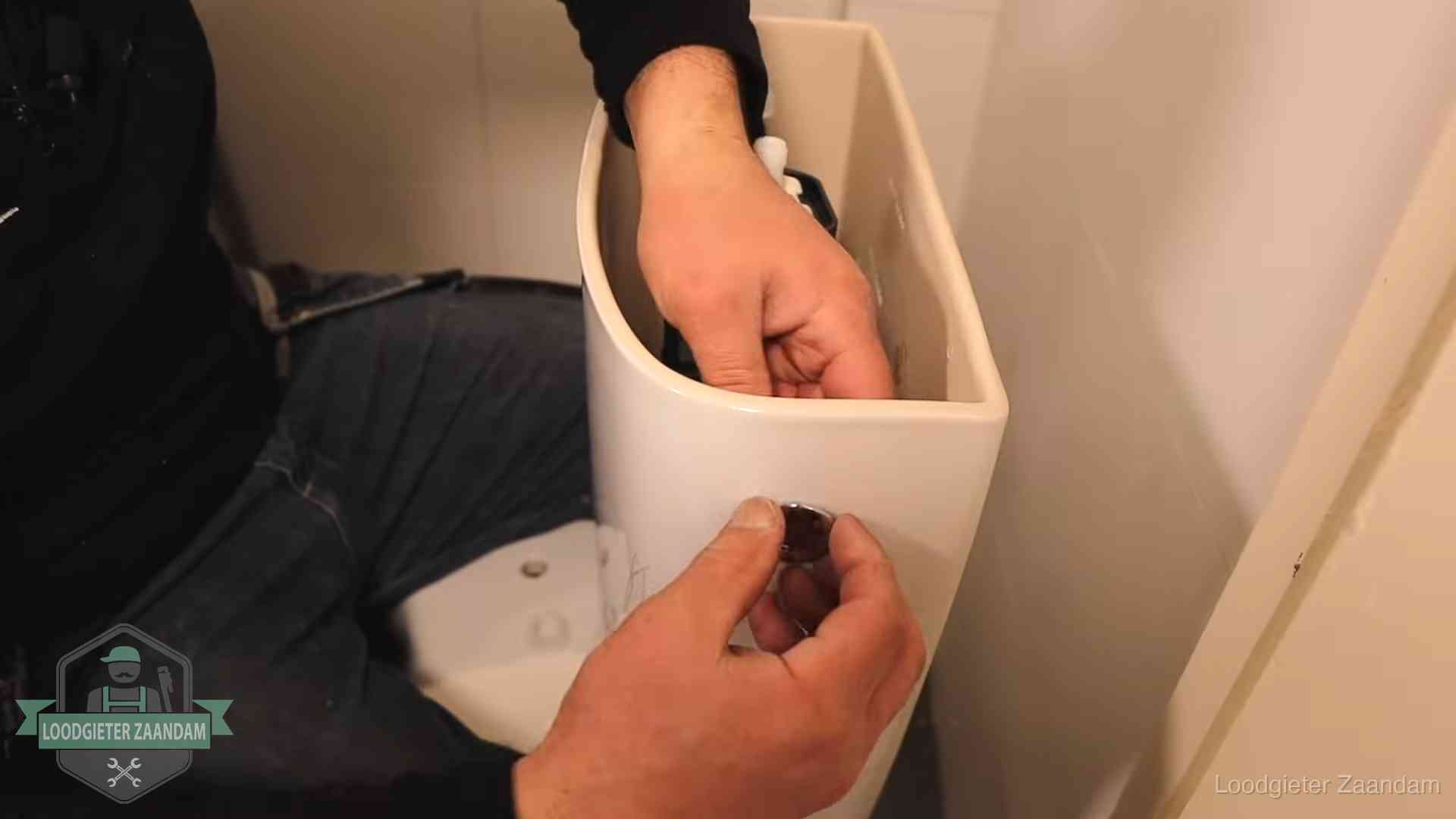 Drukknop van een duoblok-stortbak wordt gemonteerd bij een toilet in Zaandam