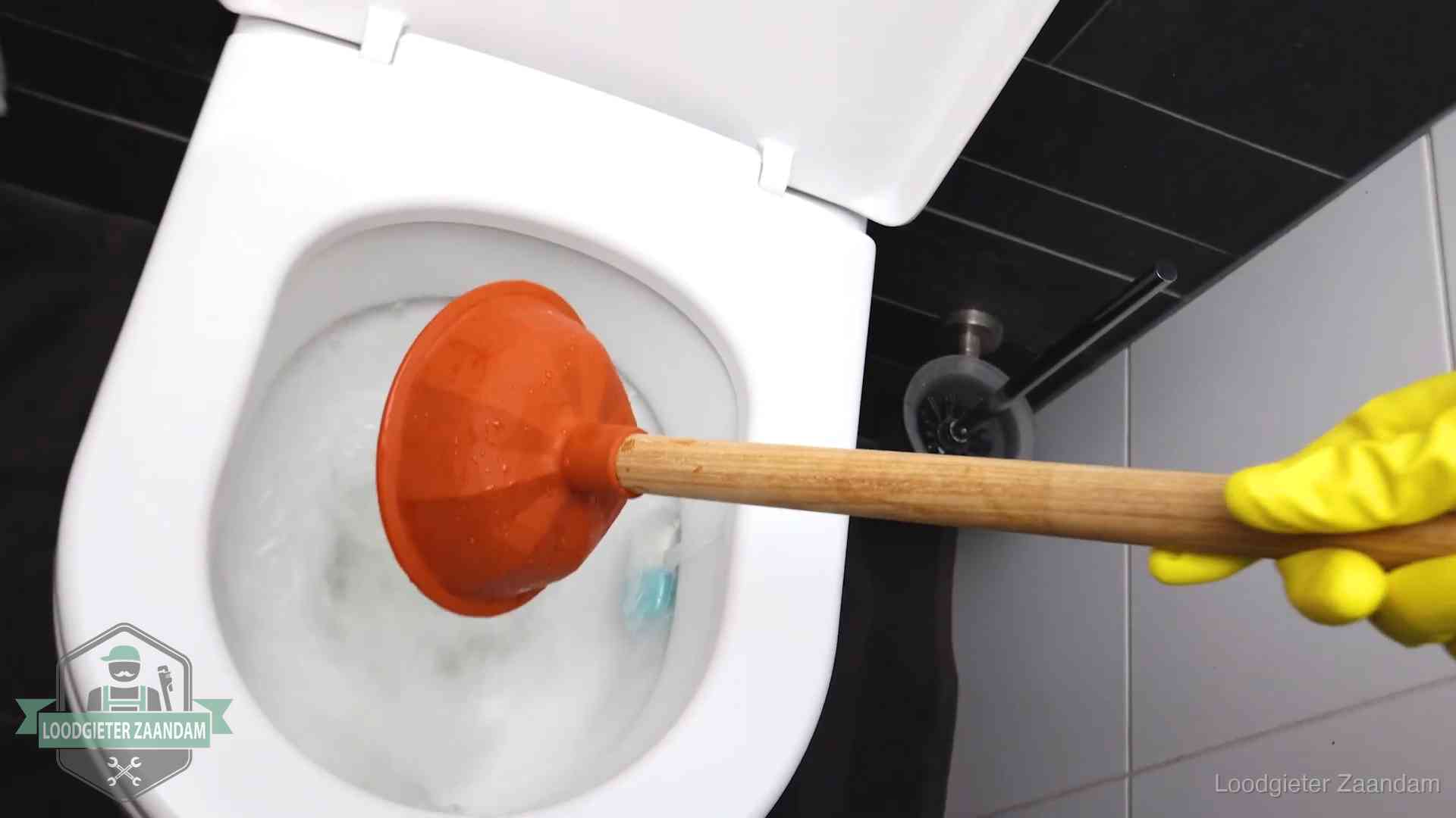 Plopper wordt in de wc-pot gedrukt bij het ontstoppen van een toilet in Zaandam