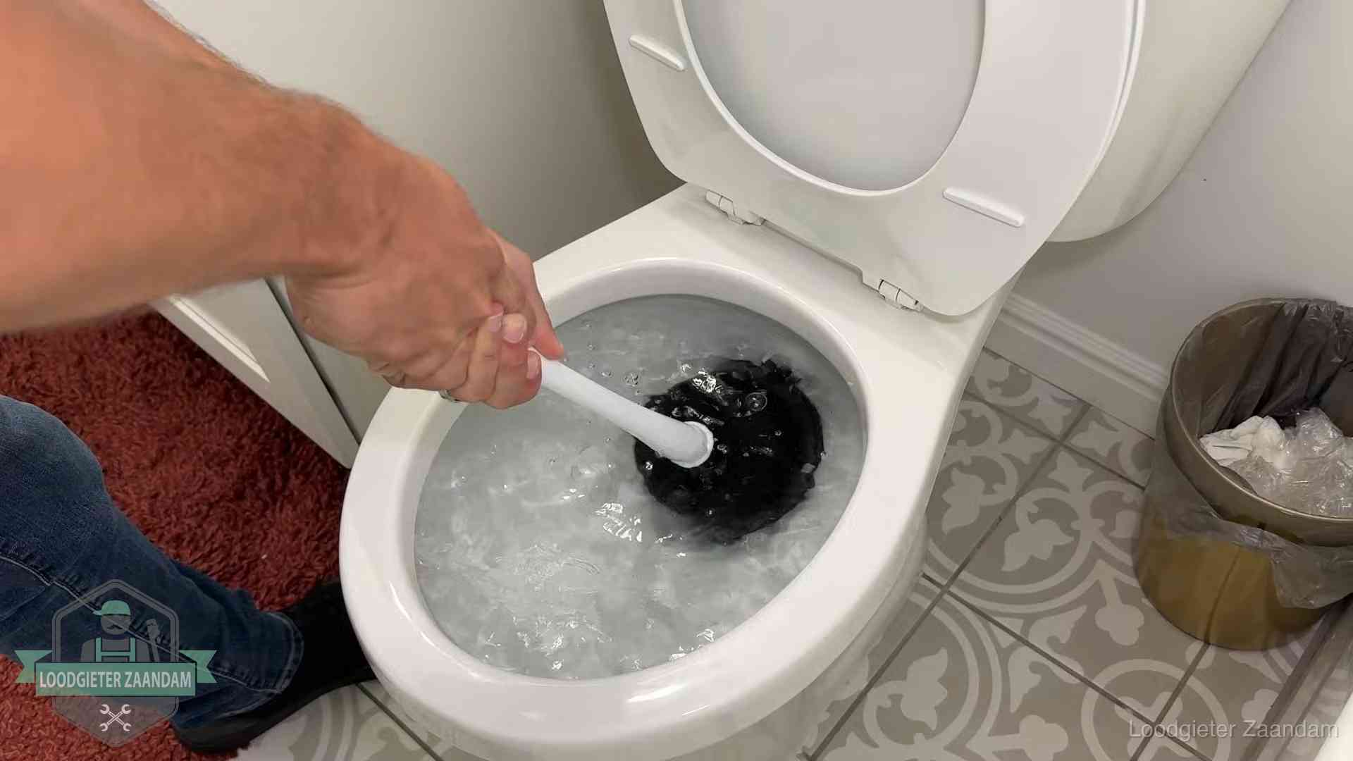 Zelf de wc ontstoppen met een plopper in Zaandam, het water kolkt in de pot